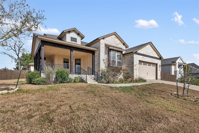 view of front of home with an attached garage, covered porch, stone siding, concrete driveway, and a front lawn