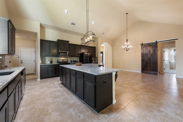 kitchen with a sink, visible vents, a center island, black refrigerator with ice dispenser, and stainless steel microwave