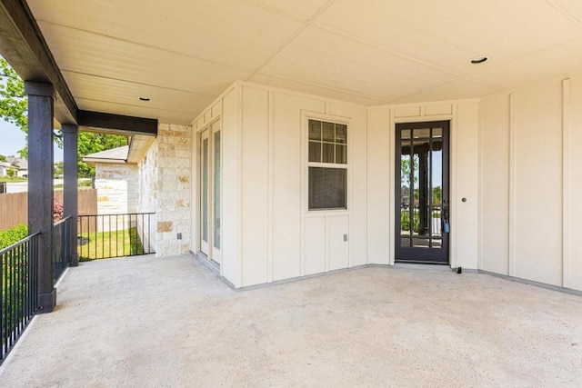 114 Darst Ln, Bastrop, TX 78602 - property entrance featuring board and batten siding, a patio area, and stone siding