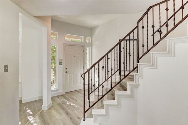entrance foyer featuring stairs, wood finished floors, and baseboards
