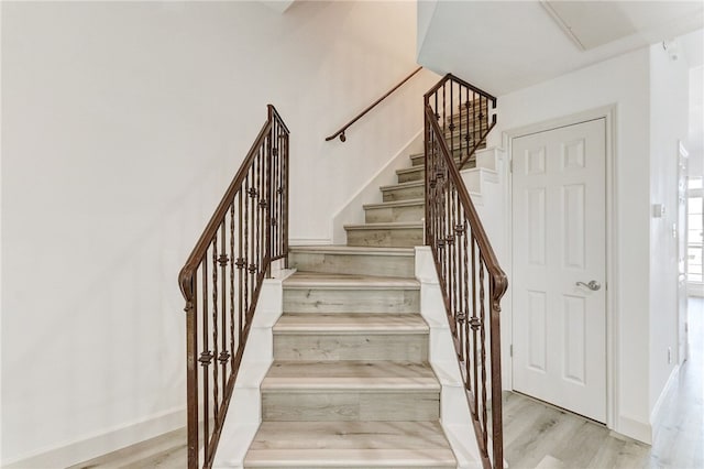 stairs featuring wood finished floors and baseboards