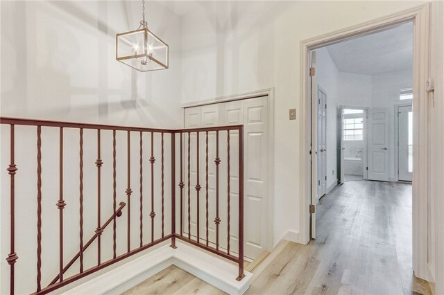 entrance foyer featuring a chandelier, light wood-type flooring, and baseboards