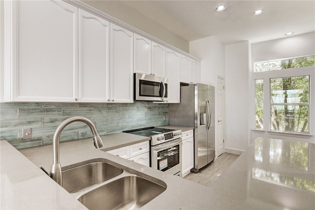 kitchen featuring appliances with stainless steel finishes, a sink, white cabinets, and recessed lighting