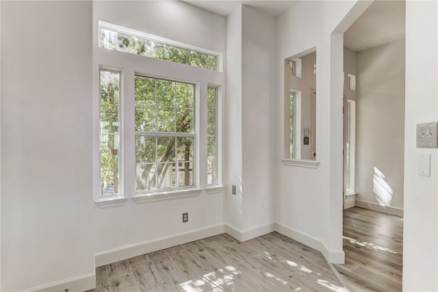 foyer with light wood-type flooring and baseboards