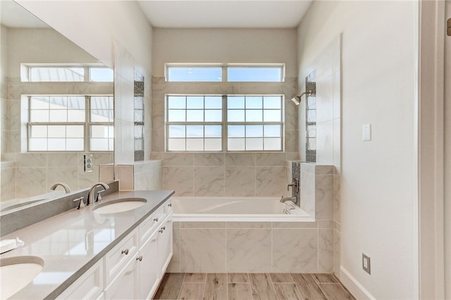 full bathroom featuring tiled shower / bath combo, double vanity, and wood finished floors
