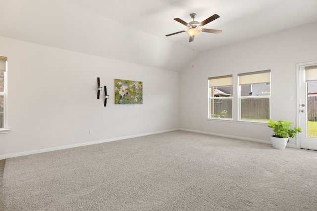 carpeted empty room with lofted ceiling, ceiling fan, and baseboards