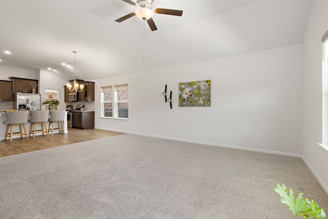 unfurnished living room featuring recessed lighting, a ceiling fan, light carpet, vaulted ceiling, and baseboards