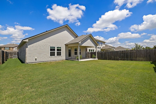 back of property with a fenced backyard, a lawn, and a patio