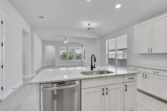 kitchen featuring lofted ceiling, a sink, visible vents, dishwasher, and tasteful backsplash