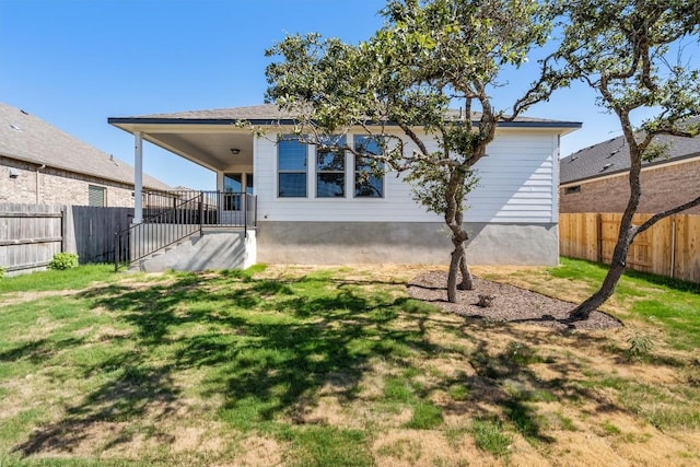 back of property featuring a fenced backyard and a yard