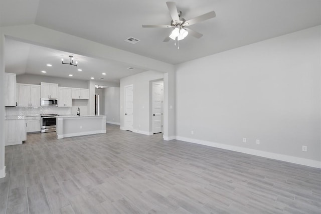 unfurnished living room featuring lofted ceiling, visible vents, baseboards, a ceiling fan, and light wood-type flooring