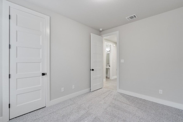 unfurnished bedroom with carpet, visible vents, and baseboards