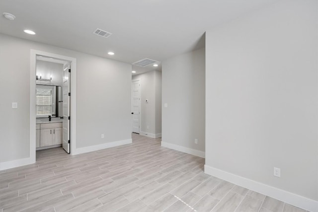 spare room with light wood-type flooring, baseboards, visible vents, and recessed lighting