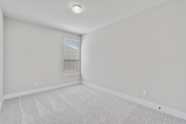 carpeted spare room with baseboards