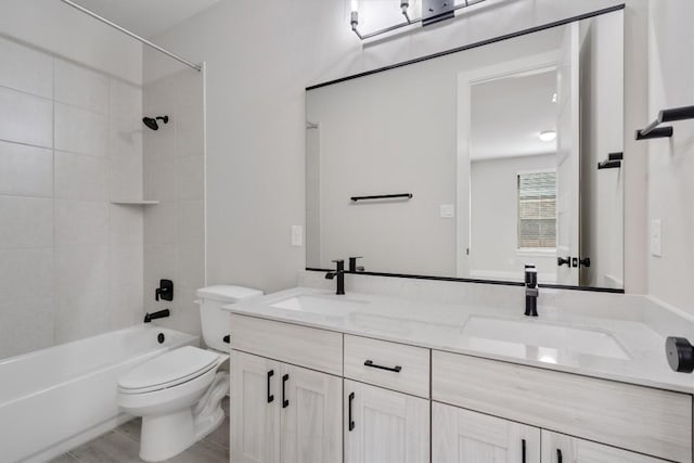 full bathroom featuring shower / washtub combination, a sink, toilet, and double vanity