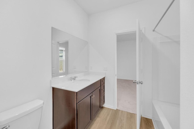 bathroom featuring wood finished floors, vanity, and toilet