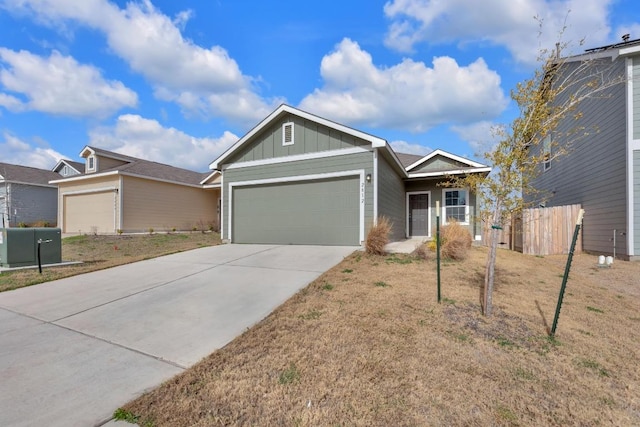 ranch-style house with board and batten siding, concrete driveway, fence, and an attached garage