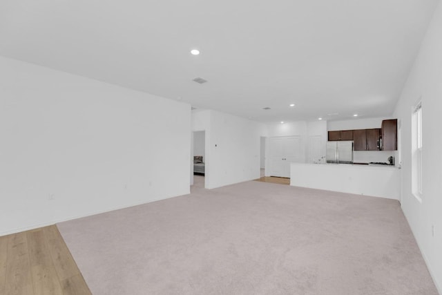 unfurnished living room with light wood finished floors, visible vents, and recessed lighting