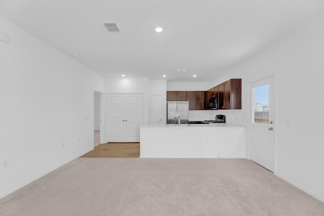 kitchen with stainless steel refrigerator with ice dispenser, light countertops, visible vents, light carpet, and a peninsula