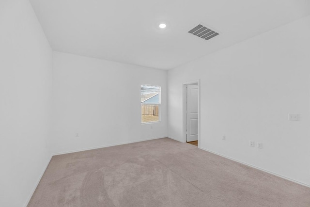 empty room featuring carpet, visible vents, baseboards, and recessed lighting