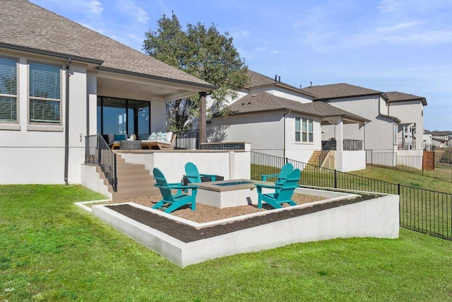 rear view of house featuring stucco siding, a shingled roof, a lawn, an outdoor fire pit, and fence