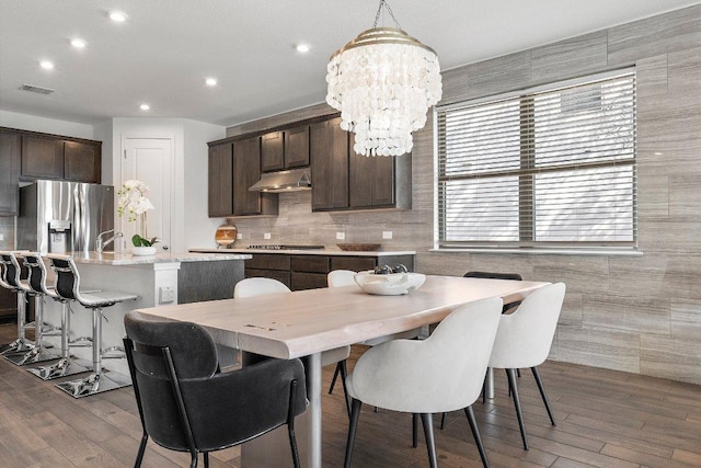 dining room with a chandelier, wood finished floors, visible vents, and recessed lighting