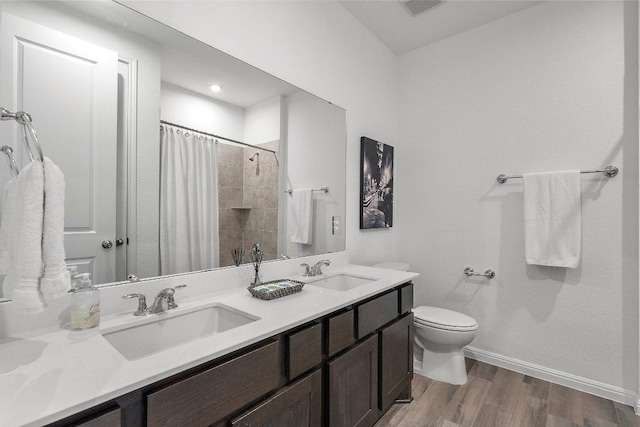 full bathroom featuring curtained shower, a sink, toilet, and wood finished floors