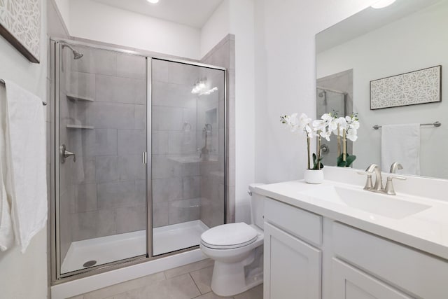 bathroom featuring vanity, tile patterned flooring, a shower stall, and toilet