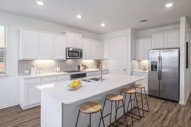 kitchen with white cabinets, visible vents, stainless steel appliances, and a sink