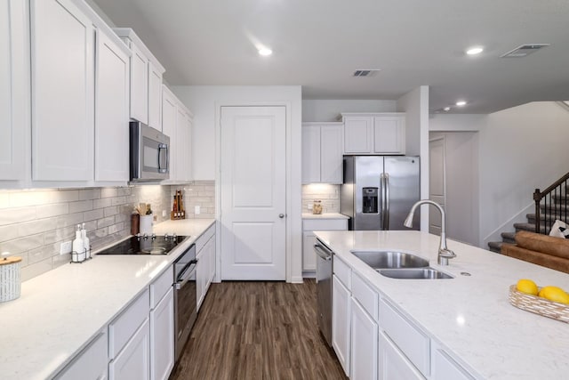 kitchen featuring appliances with stainless steel finishes, a sink, visible vents, and white cabinetry