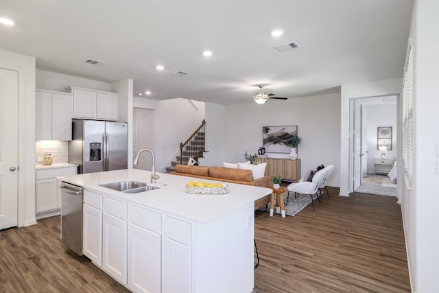 kitchen with dark wood-style floors, stainless steel appliances, a sink, and light countertops