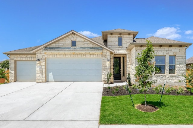 view of front of house featuring a garage, a shingled roof, a front lawn, and concrete driveway