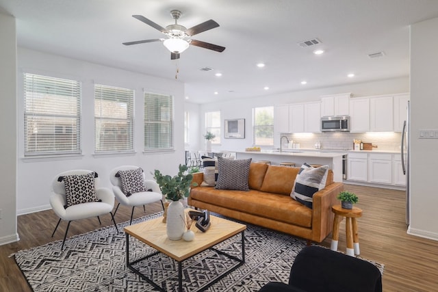 living room featuring ceiling fan, visible vents, wood finished floors, and recessed lighting