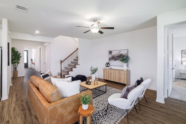 living area with visible vents, stairway, a ceiling fan, wood finished floors, and baseboards