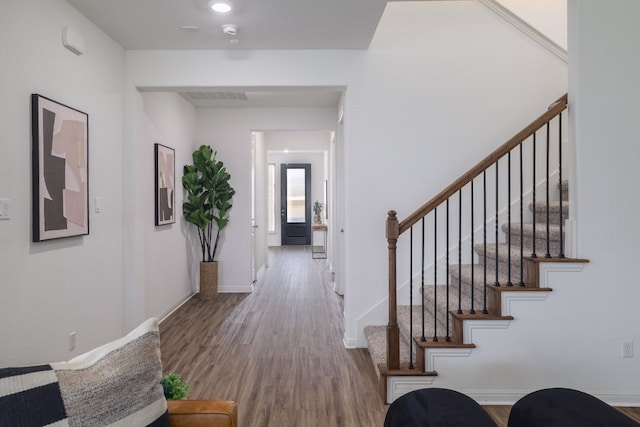 interior space featuring stairs, wood finished floors, visible vents, and baseboards