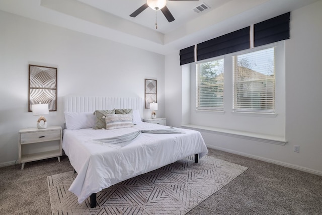 bedroom featuring carpet floors, a raised ceiling, visible vents, and baseboards