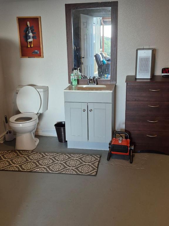 bathroom with vanity, toilet, baseboards, and concrete floors