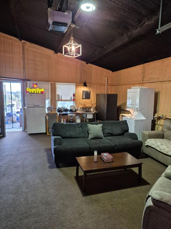 carpeted living room featuring vaulted ceiling with beams and an inviting chandelier