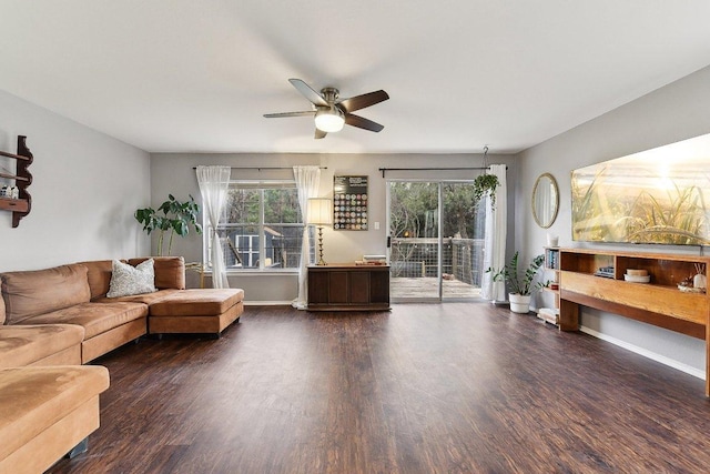 living room with a ceiling fan, baseboards, and wood finished floors