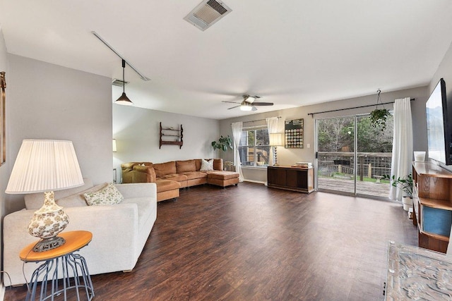 living room featuring dark wood-style flooring, visible vents, and ceiling fan