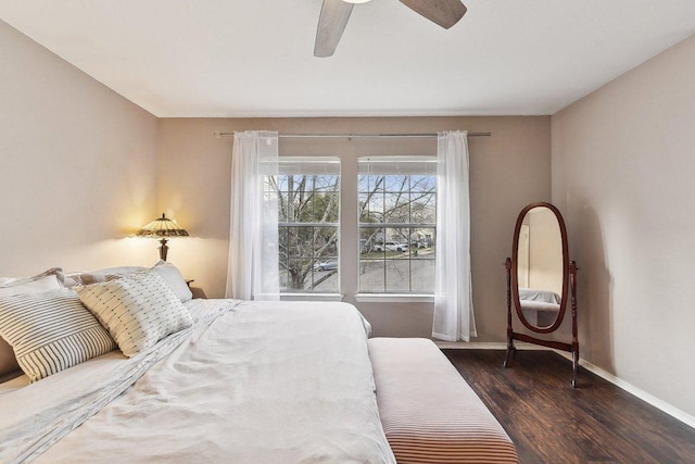 bedroom featuring a ceiling fan, baseboards, and wood finished floors