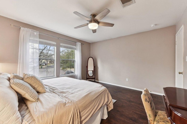 bedroom featuring a ceiling fan, baseboards, visible vents, and wood finished floors