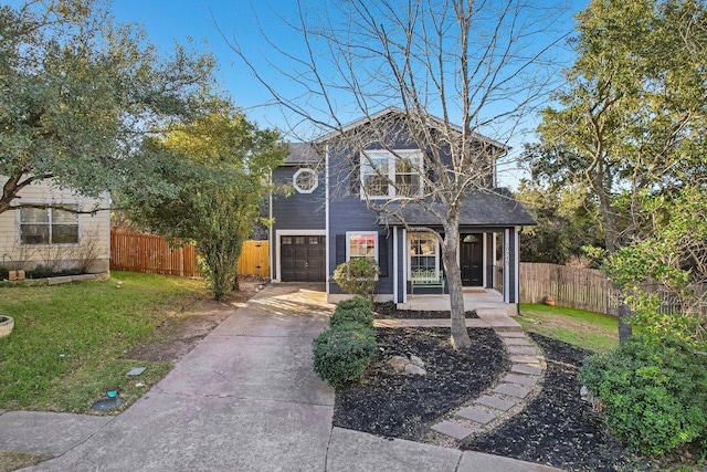 traditional home with covered porch, fence, a garage, driveway, and a front lawn