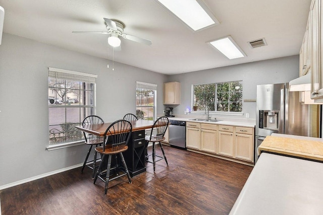 kitchen with visible vents, stainless steel appliances, light countertops, light brown cabinets, and a sink