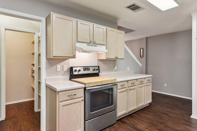 kitchen with dark wood-style flooring, stainless steel electric range oven, light countertops, visible vents, and under cabinet range hood