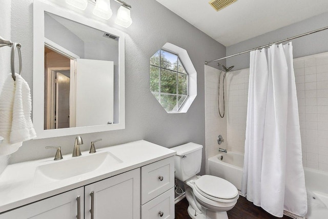 bathroom featuring toilet, vanity, visible vents, and shower / bathtub combination with curtain