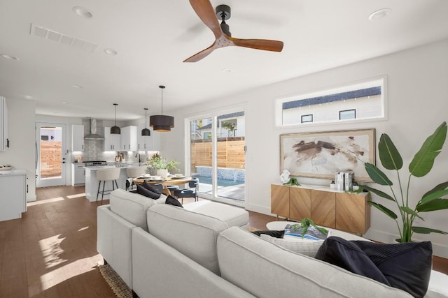 living area with visible vents, dark wood finished floors, recessed lighting, baseboards, and ceiling fan