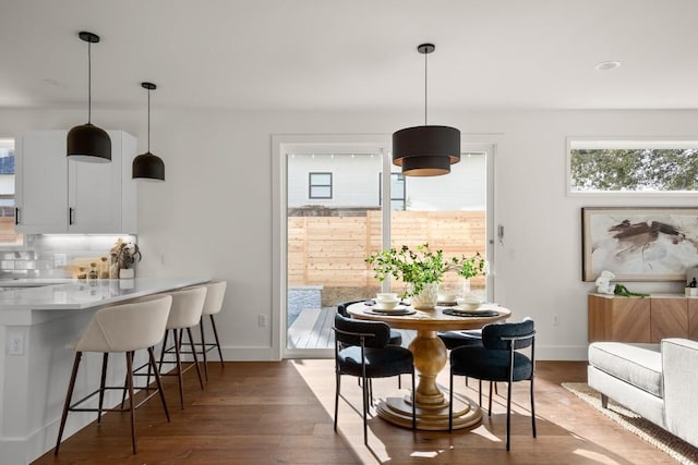 dining area with baseboards and wood finished floors