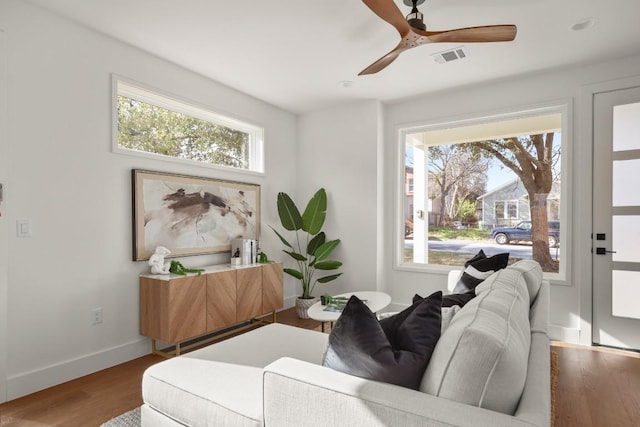 sitting room featuring baseboards, plenty of natural light, visible vents, and wood finished floors