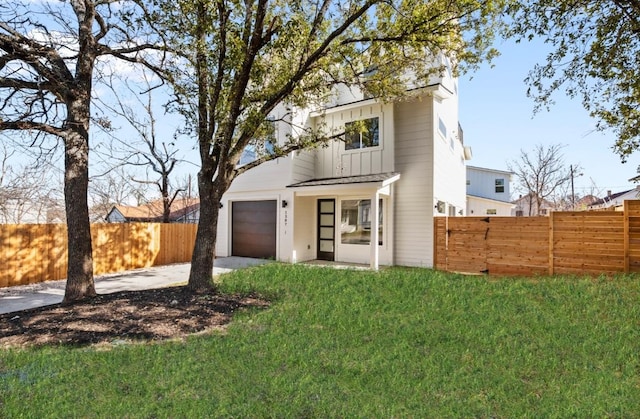 exterior space featuring fence, driveway, an attached garage, a yard, and board and batten siding